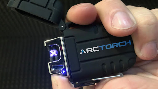A sleek ArcTorch lighter, emitting a high-intensity electric arc, with a background of flames.