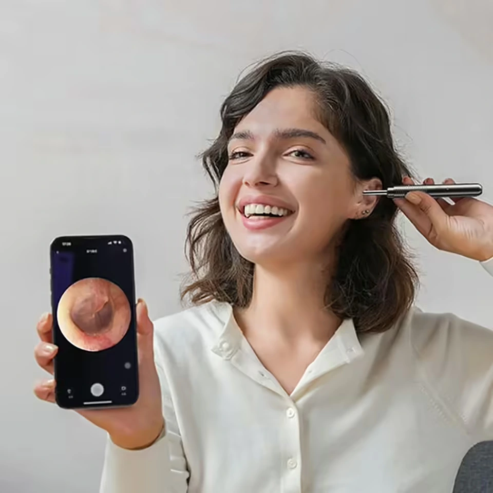 A Guirl Is using An EaroPro Ear Wax Cleaner And Smiling While Using The EaroPro EarWax Cleaner Device.